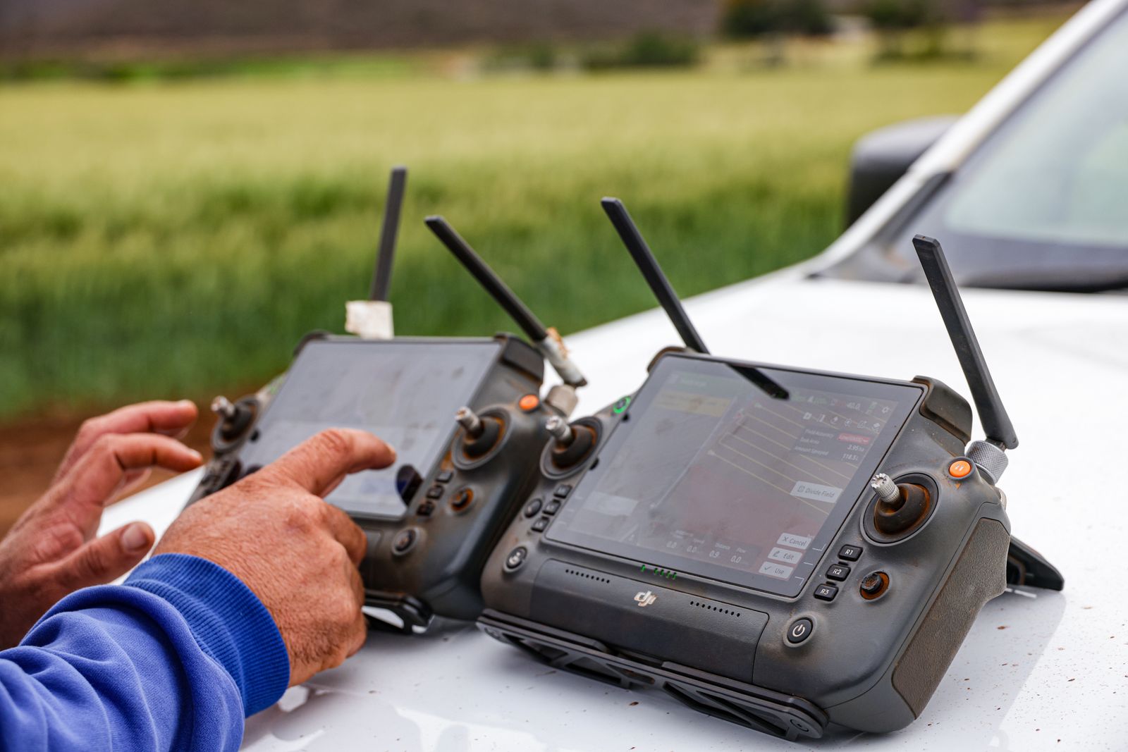Productores operan controles de drones agrícolas en un campo